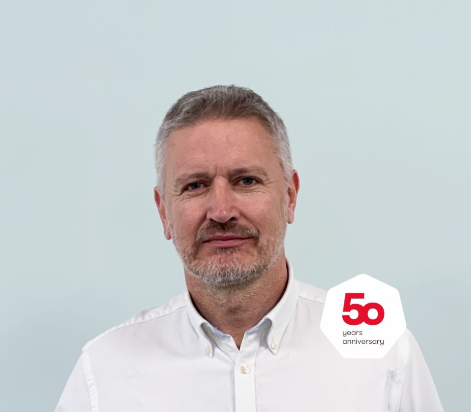 Anthony Jenks Geschäftsführer EOS Solutions, UK steht mit einem hellen Hemd vor hellem Grund.Anthony Jenks Geschäftsführer EOS Solutions, UK steht mit einem hellen Hemd vor hellem Grund.