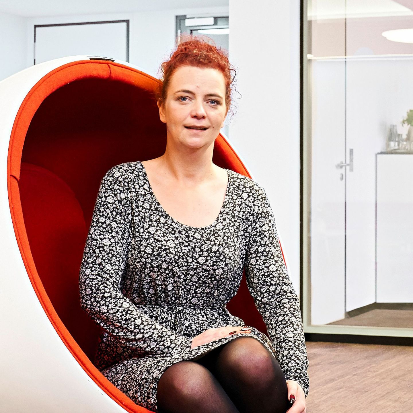 Interview: Call Center Agentin Katja Wolf sitzt in einem Sessel.