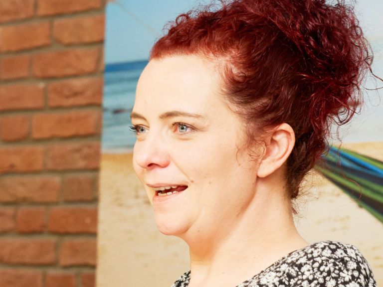 Interview: Call Center Agentin Katja Wolf sitzt in einem Sessel.