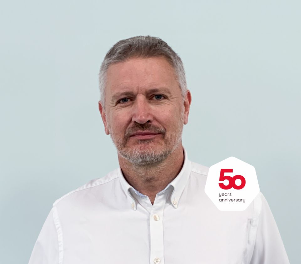 Anthony Jenks Geschäftsführer EOS Solutions, UK steht mit einem hellen Hemd vor hellem Grund.Anthony Jenks Geschäftsführer EOS Solutions, UK steht mit einem hellen Hemd vor hellem Grund.