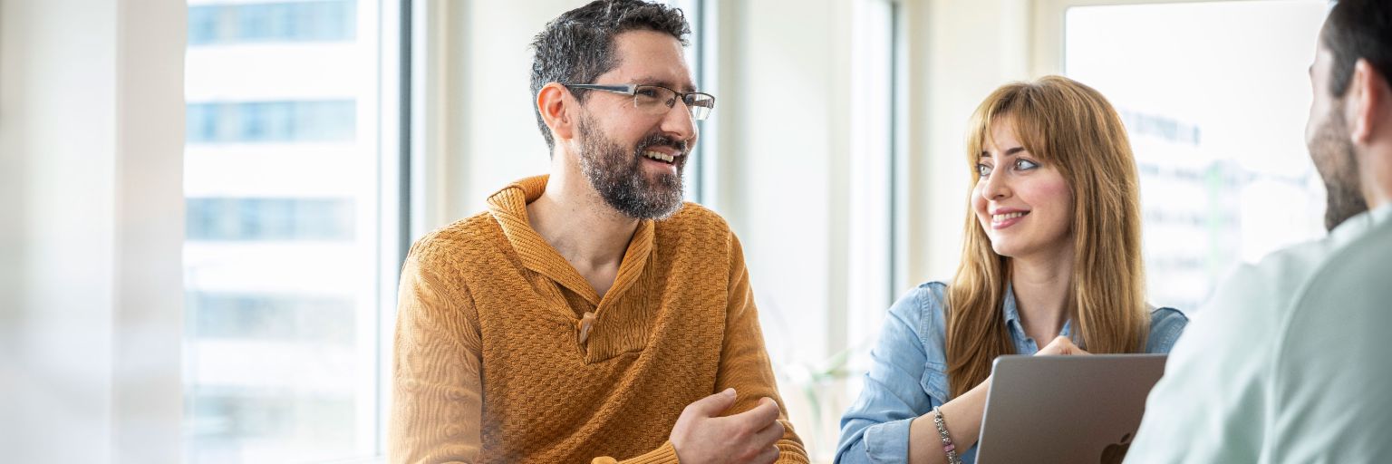 Team von drei EOS-Kollegen diskutiert an einem Stehtisch