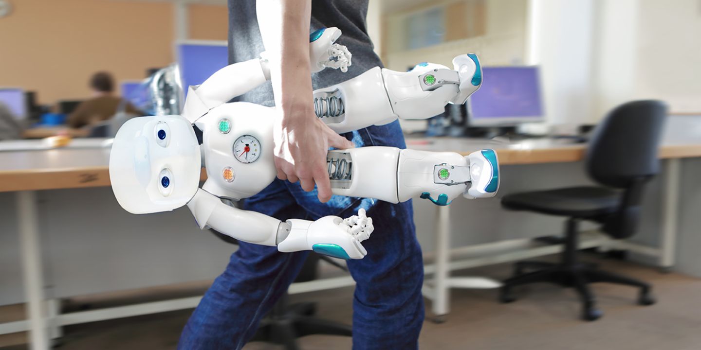 KI im Kundenservice: Mitarbeiter trägt Roboter durch das Büro