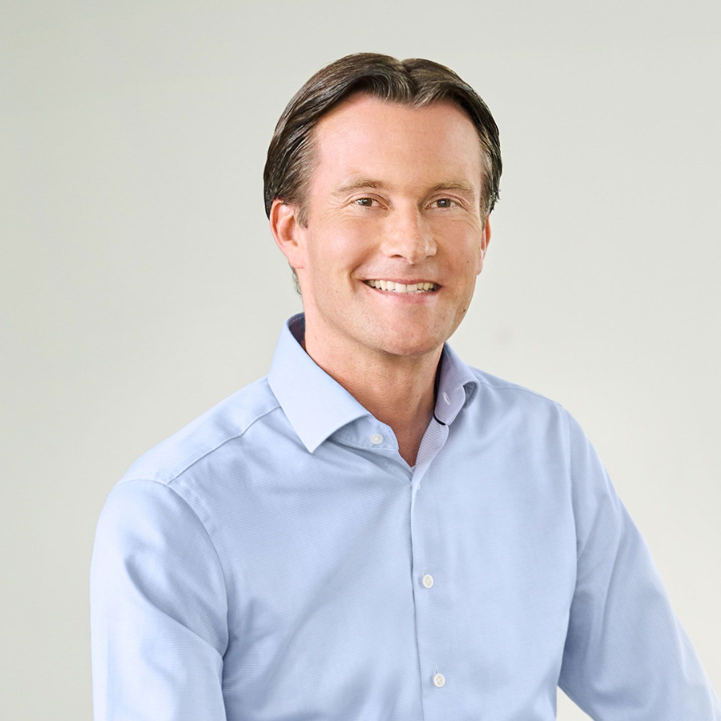Carsten Tidow, directeur du groupe EOS et responsable de l’Europe de l’Est Carsten Tidow, homme assis de manière décontractée dans une pièce lumineuse, vêtu d’une chemise bleue claire